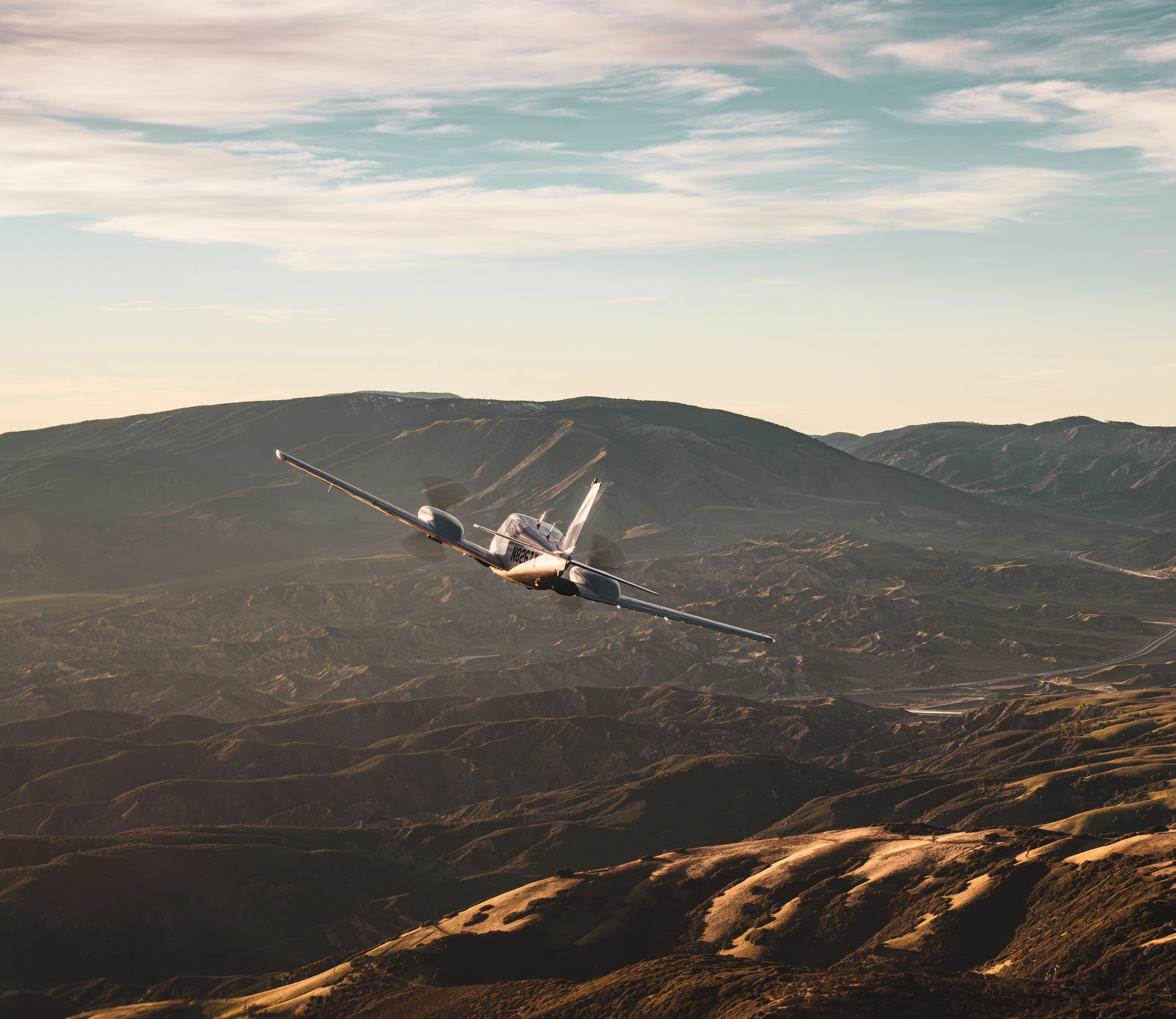 MH Aviation single-engine aircraft flying near mountain terrain