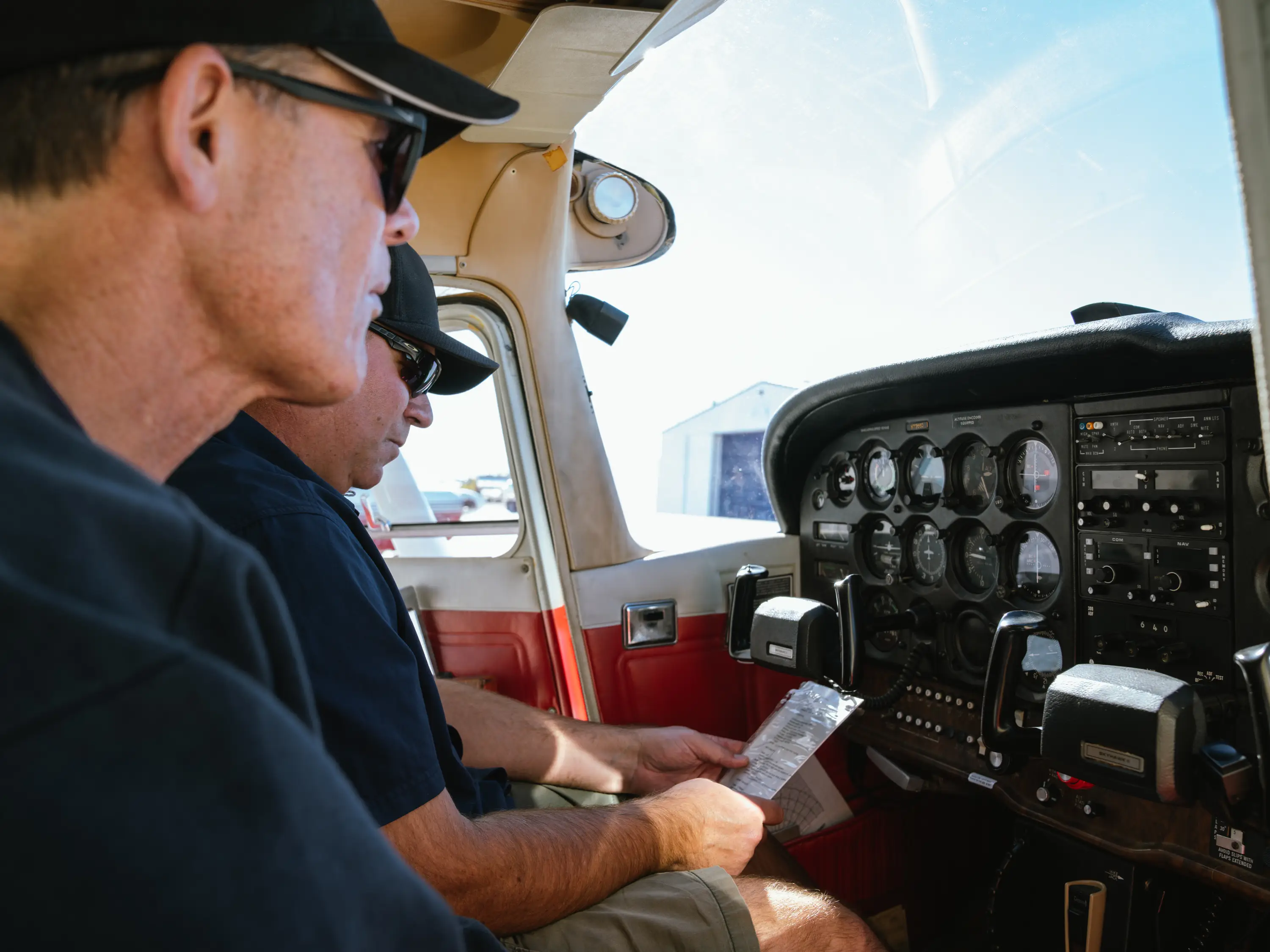 MH Aviation instructor and student reviewing a cockpit checklist before flight